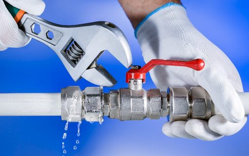 Hands plumber at work in a bathroom, plumbing repair service. Leak of water. Repair plumbing.